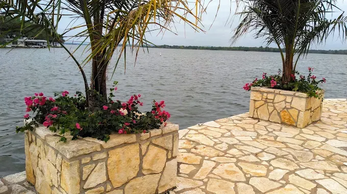 Lakefront stone planter cared for by LBJ Gardens at a residential property in Kingsland, Texas near Lake LBJ