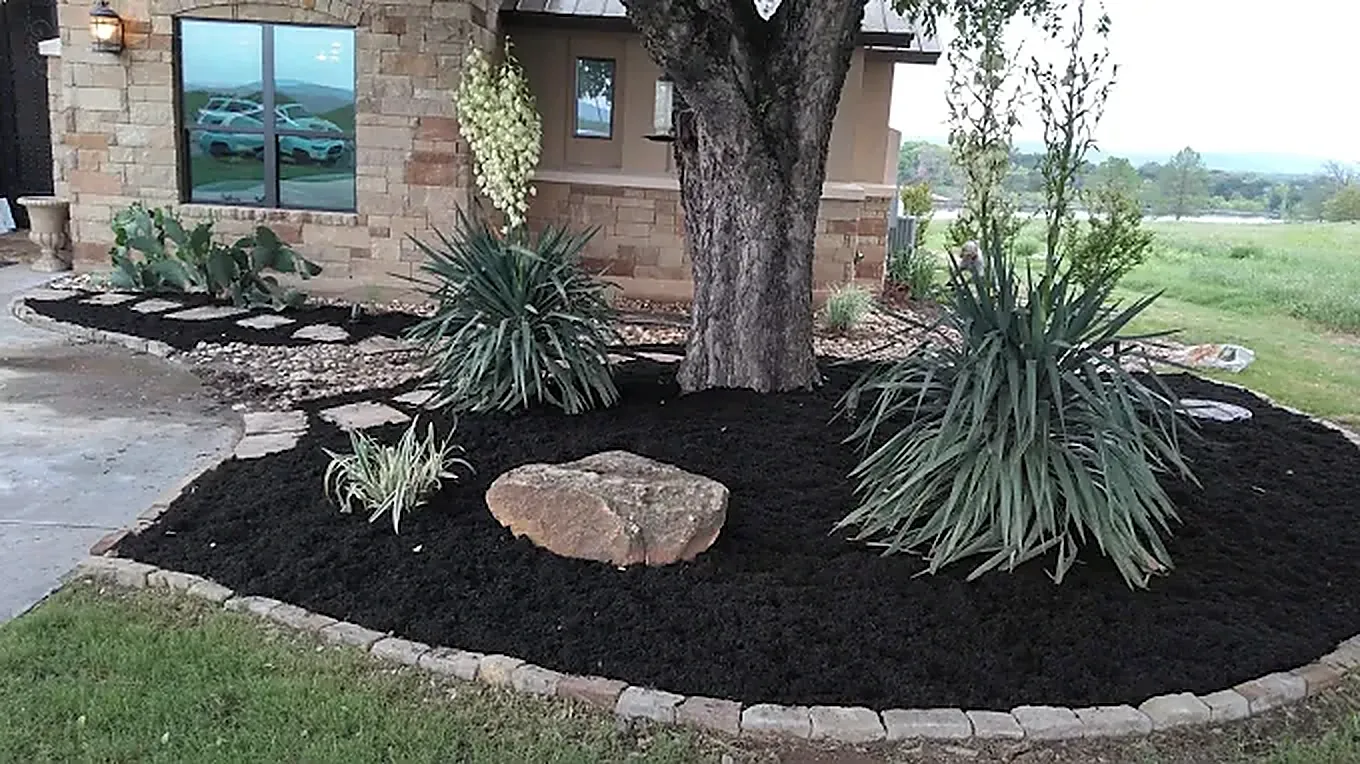 Mulched landscape bed cared for by LBJ Gardens at a residential property in Kingsland, Texas near Lake LBJ