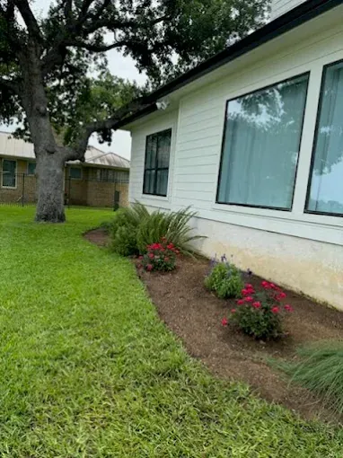 Side yard garden maintenance cared for by LBJ Gardens at a residential property in Kingsland, Texas near Lake LBJ